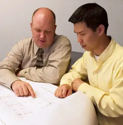 Architects Looking at Blueprints of a Prison